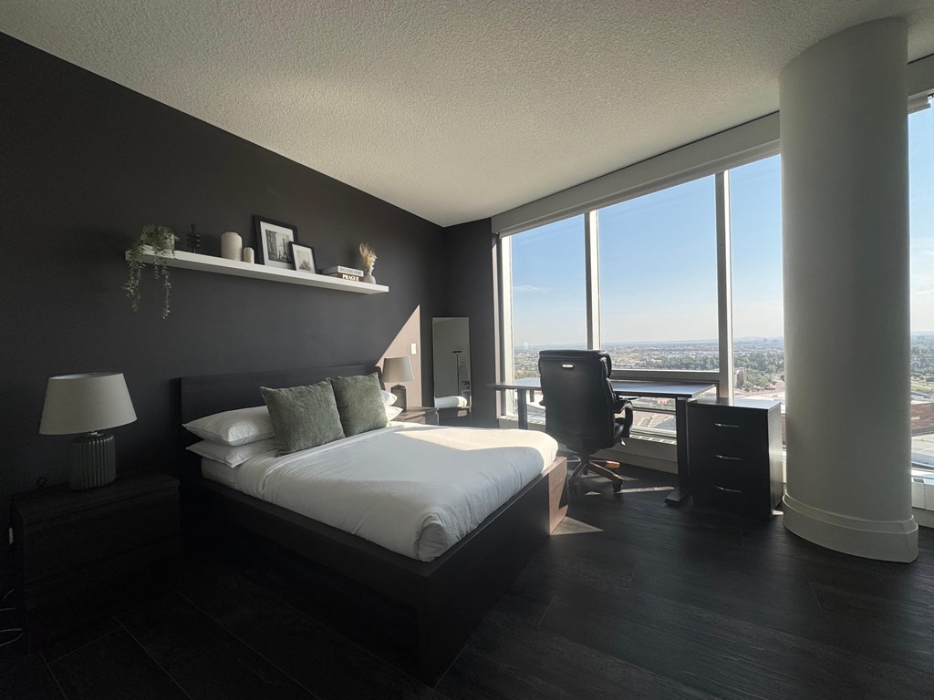 A bedroom with a large bed and a view of the city.