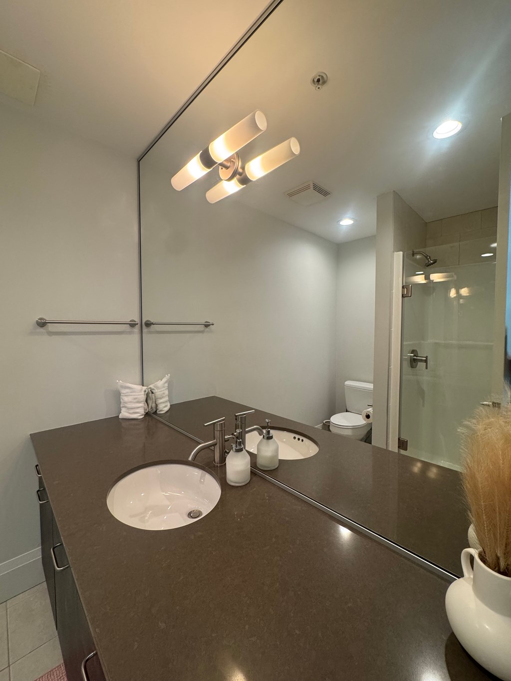 A bathroom with a brown countertop and a large mirror.