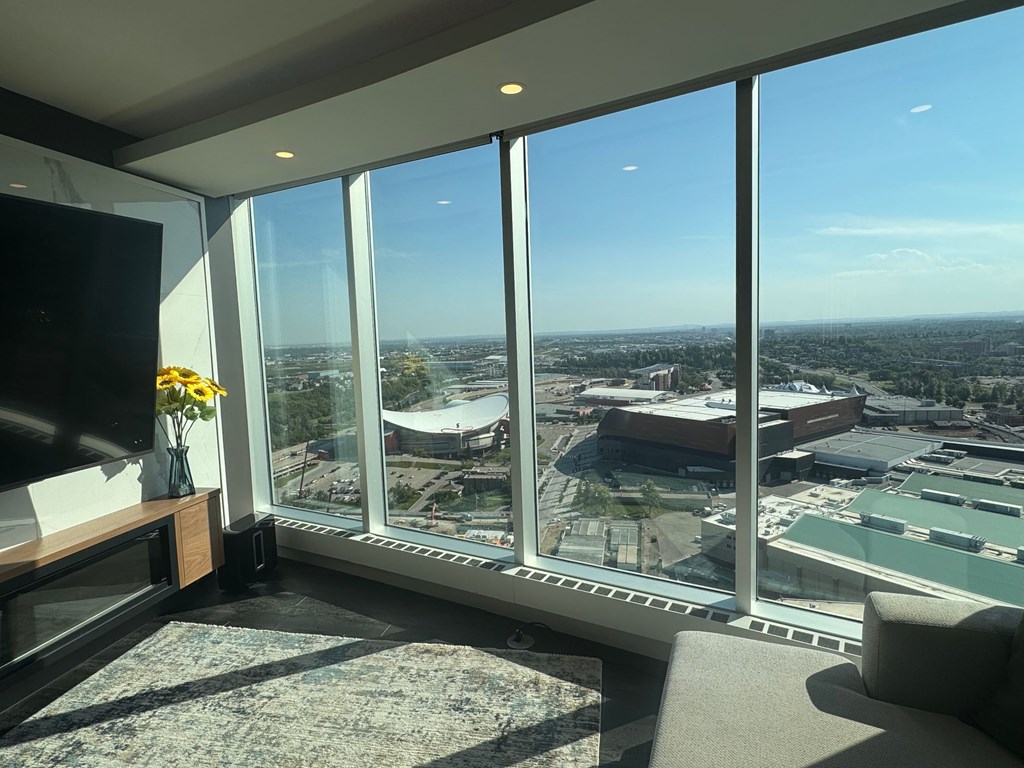 A living room with a flat screen TV and a view of the city.