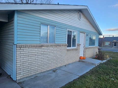 A blue house with a white door and windows.