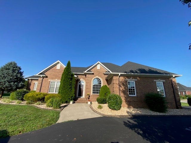 A house with a brick facade and a driveway in front.
