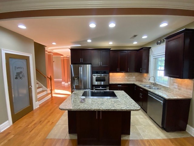 A kitchen with dark wood cabinets and a granite countertop.