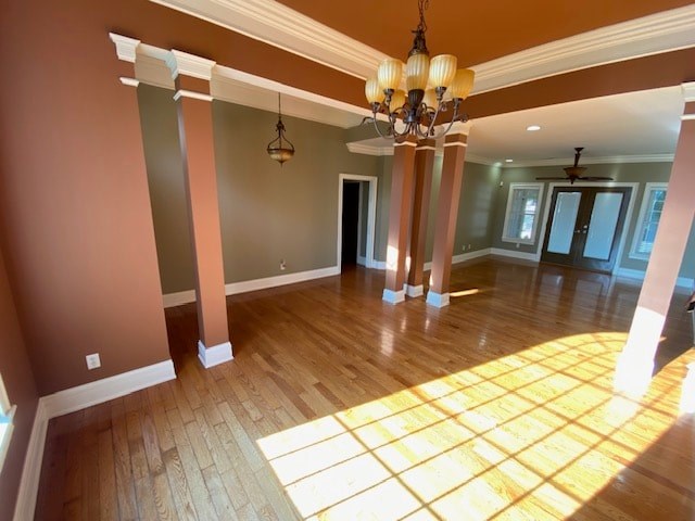A room with wooden floors and a chandelier hanging from the ceiling.
