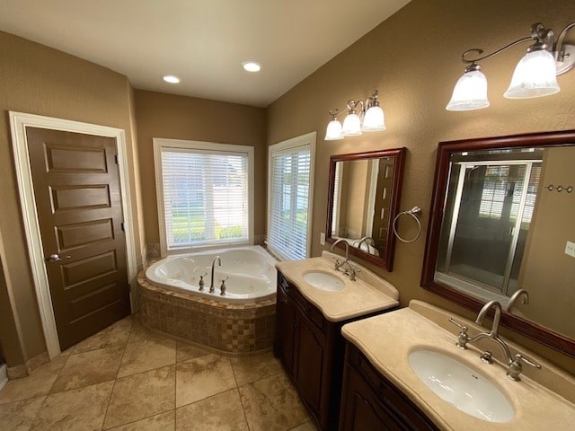 A bathroom with a tub, sink, and mirror.