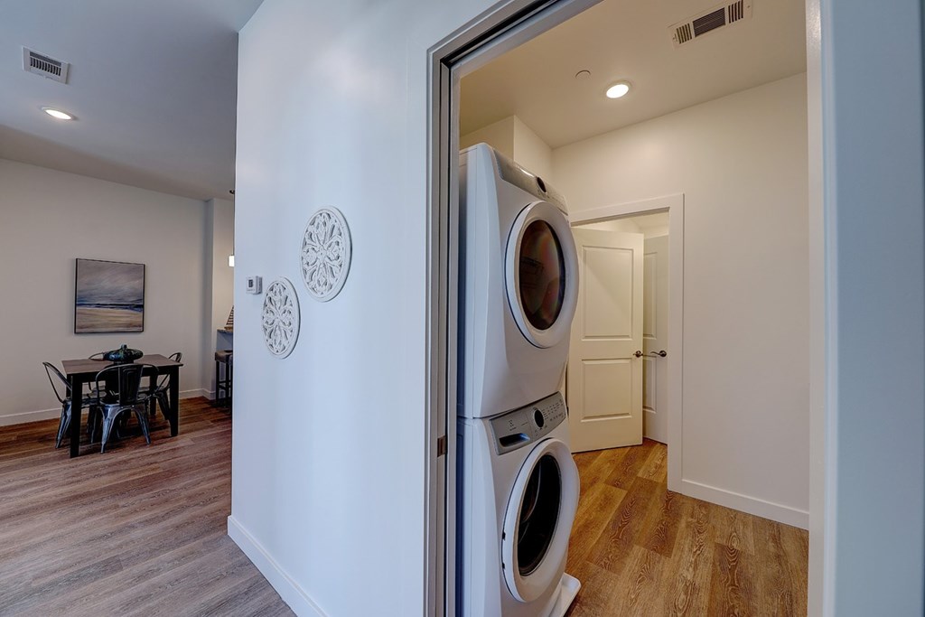 A washer and dryer are stacked in a small room.