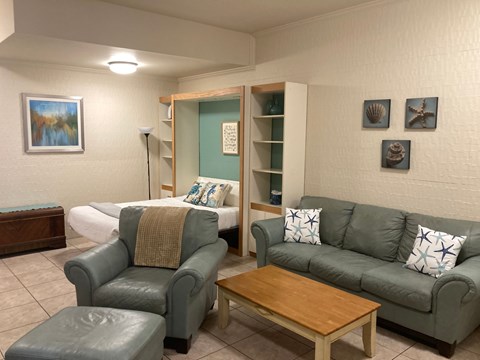 A living room with a grey couch, a brown coffee table, and a grey chair.