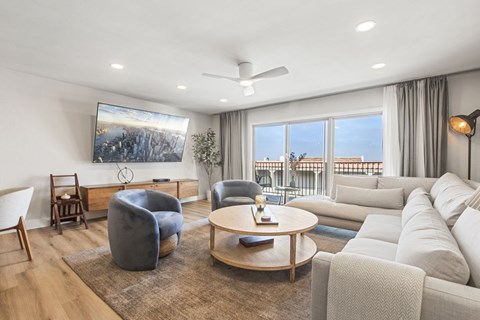 A living room with a large painting on the wall and a view of the city outside the window.