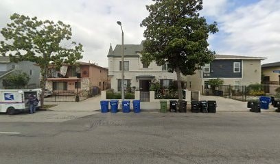 A white mail truck is parked on the left side of a street.