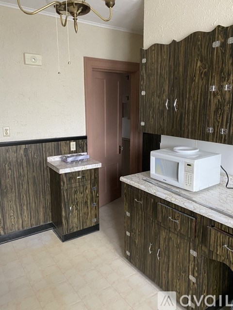 A kitchen with wooden cabinets and a white microwave oven.