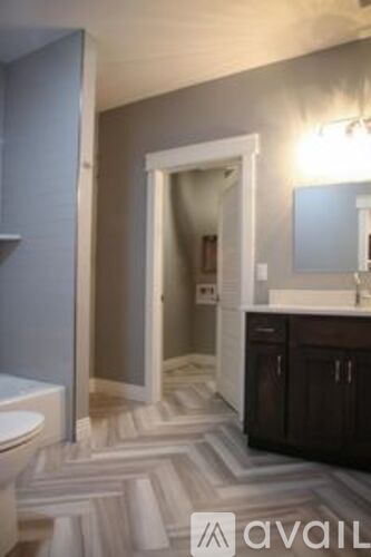 A bathroom with a toilet, sink, and mirror.