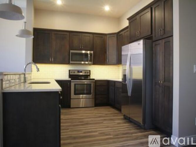 A kitchen with dark wood cabinets and stainless steel appliances.