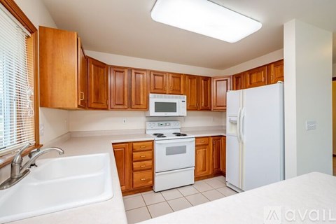 A kitchen with wooden cabinets and white appliances.