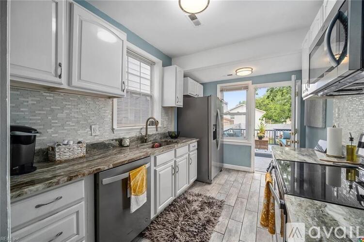 A kitchen with a stone backsplash and a window with blinds.