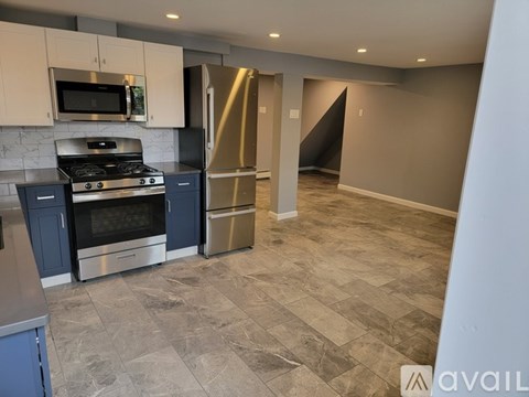 A kitchen with a stove top oven and a refrigerator.
