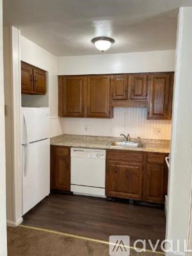 A kitchen with wooden cabinets and white appliances.