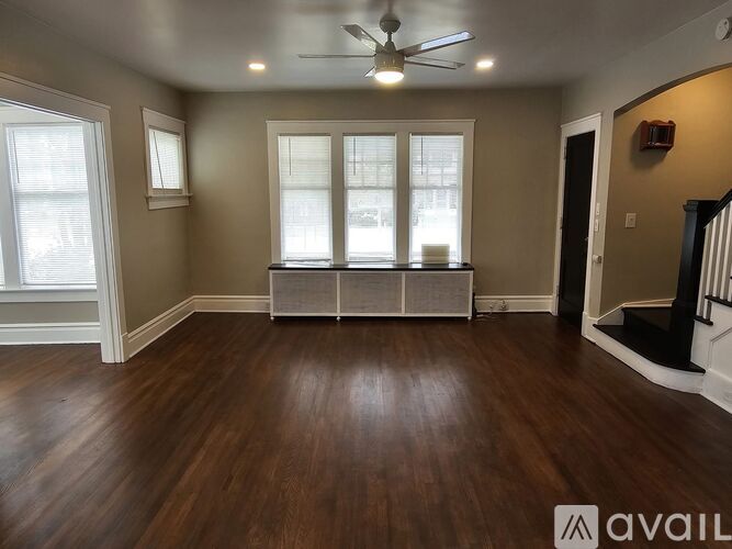 A room with a ceiling fan and wooden flooring.