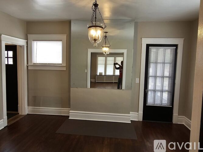 A room with a large mirror and a chandelier hanging from the ceiling.