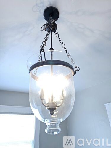 A chandelier with a glass globe and metal chain hanging from the ceiling.