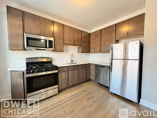 A kitchen with wooden cabinets and stainless steel appliances is available for rent.
