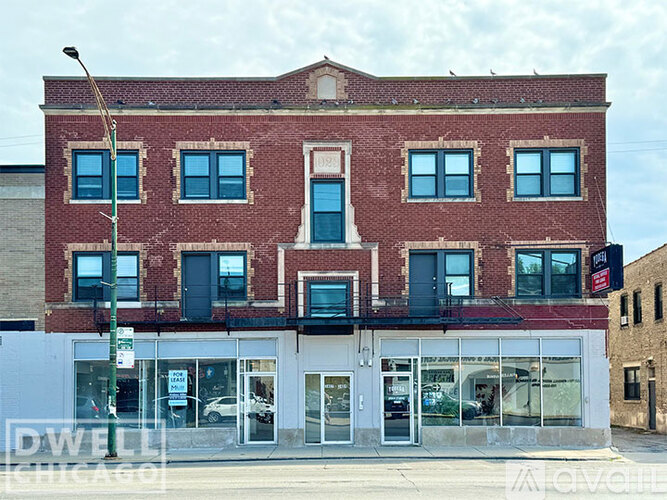 A red brick building with a white awning and a sign that says Dwell Chicago.