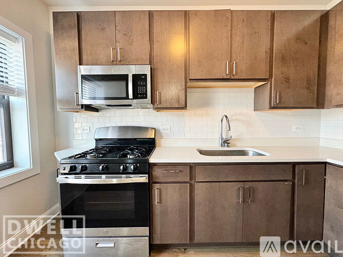 A kitchen with a stove, sink, and cabinets.