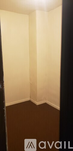 A room with white walls and brown flooring.