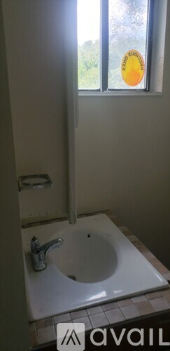 A bathroom with a window and a sink.