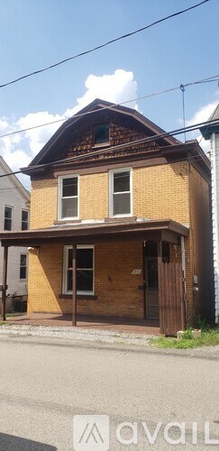 A house with a brown roof and a brick exterior is shown.