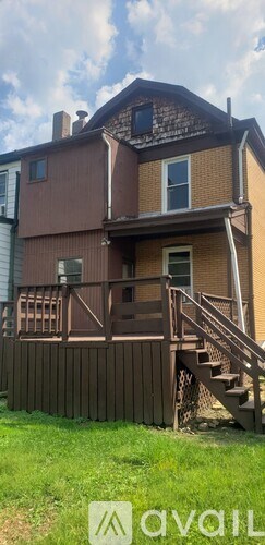 A brown house with a white window and a brown fence.