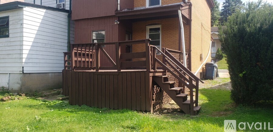 A brown house with a wooden deck and stairs.