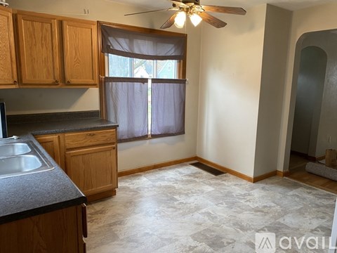 A kitchen with wooden cabinets and a ceiling fan.