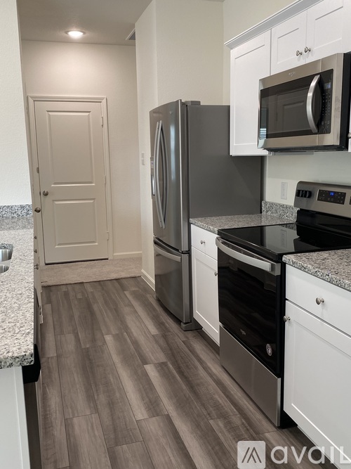 A kitchen with a refrigerator, oven, and microwave.