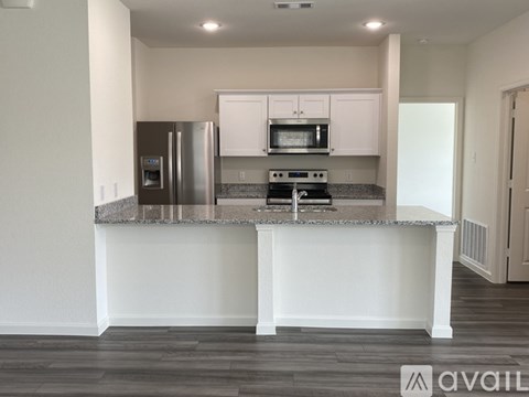 A kitchen with a stove top oven and a refrigerator.