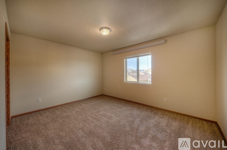 A room with a window and carpeted floor.