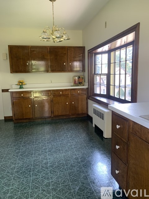A kitchen with wooden cabinets and a chandelier.