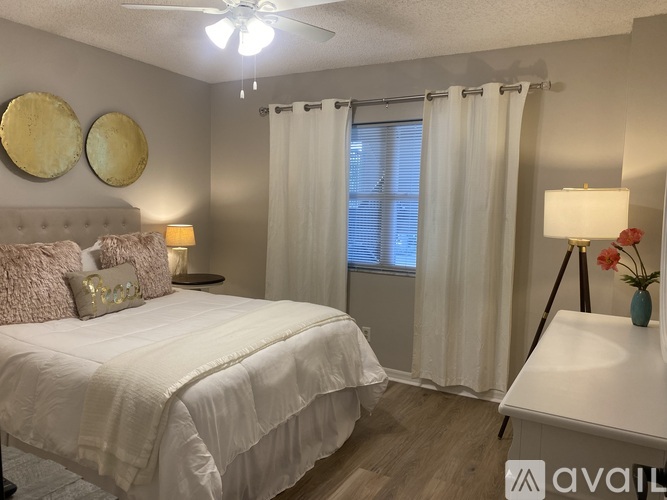 A bedroom with a large bed and a window with curtains.