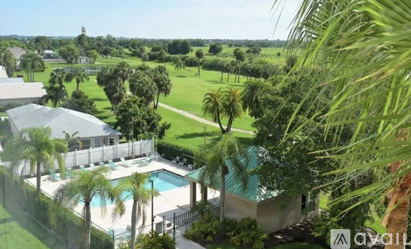 A pool surrounded by a fence and trees.
