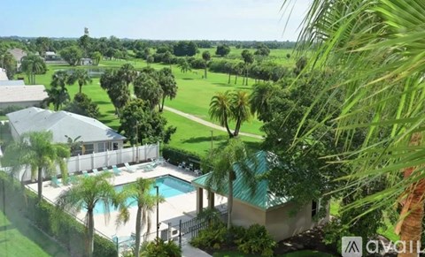A pool surrounded by a fence and trees.