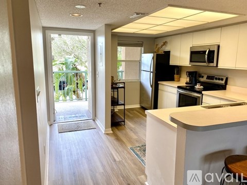 A kitchen with white cabinets and a refrigerator.
