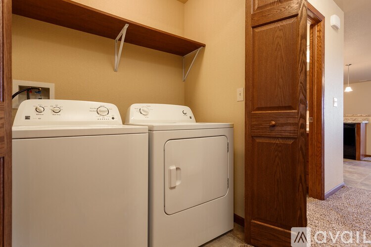 Two white front loading washing machines in a laundry room.