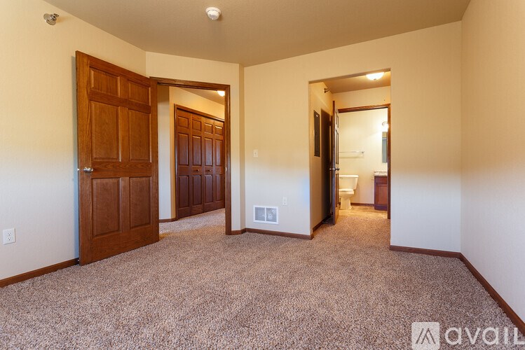 A room with a carpeted floor and a door on the left side.