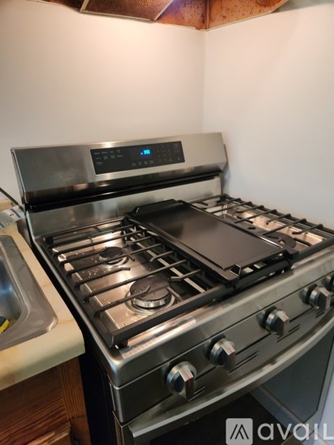 A modern gas stove with a digital control panel is installed in a kitchen.