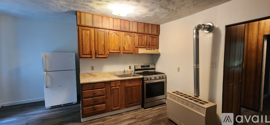 A kitchen with wooden cabinets and a white refrigerator.