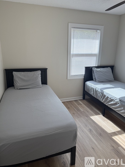 A bedroom with two beds and a window.