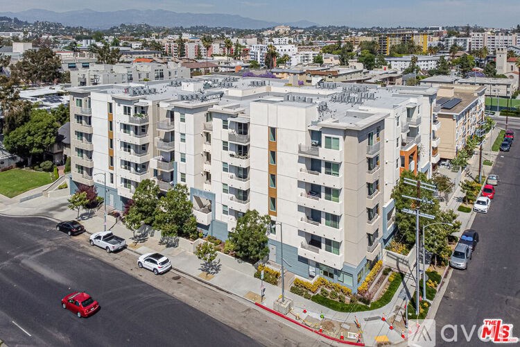 A modern apartment building with cars parked in front.