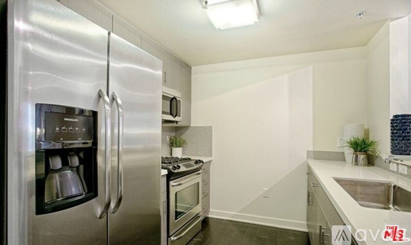 A modern kitchen with stainless steel appliances and a white countertop.