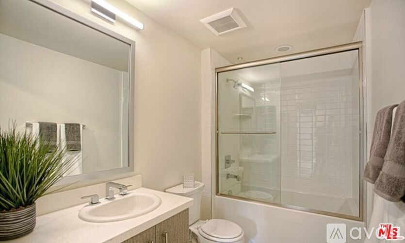 A bathroom with a toilet, sink, and mirror.