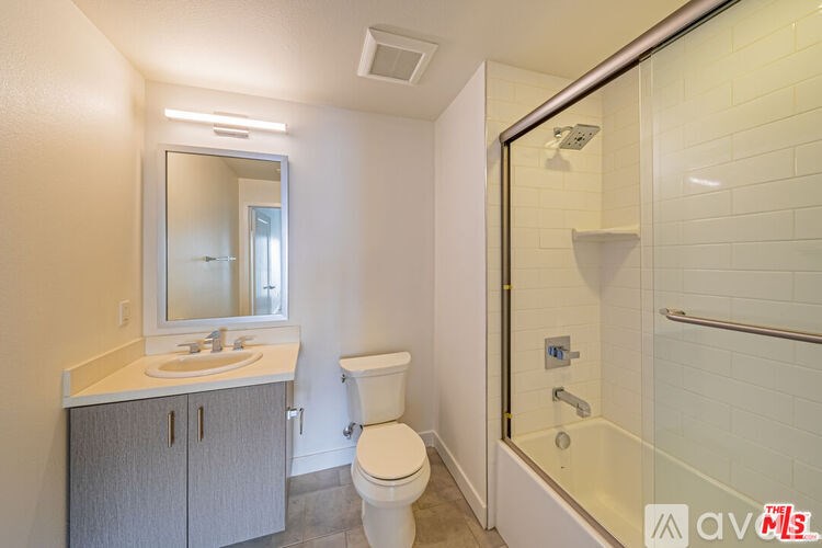 A bathroom with a toilet, sink, and shower.