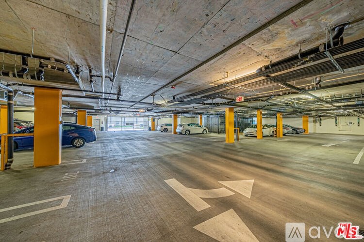 A parking garage with a blue car parked in the foreground.