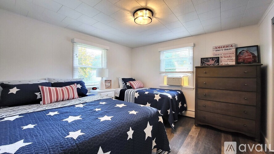 A bedroom with two beds and a dresser.